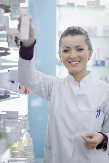 Happy cheerful pharmacist chemist woman standing in pharmacy drugstore