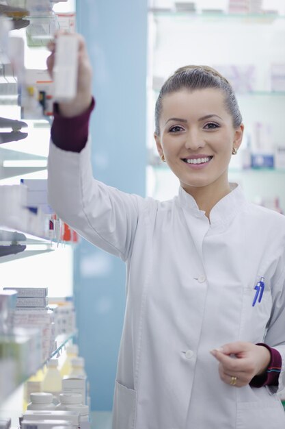 Photo happy cheerful pharmacist chemist woman standing in pharmacy drugstore