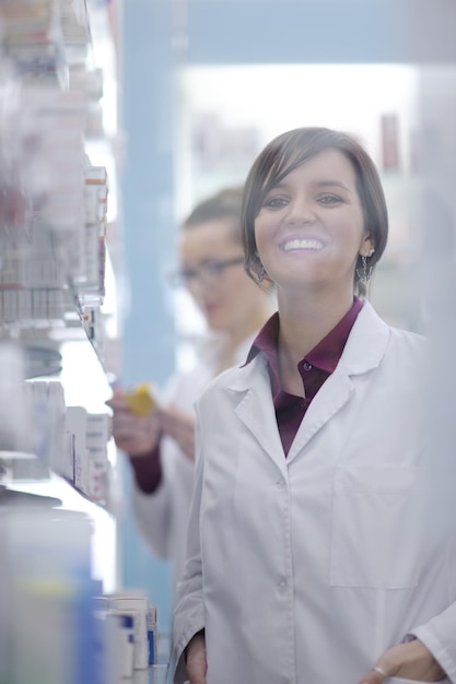 Foto felice allegra farmacista chimico donna in piedi in farmacia farmacia