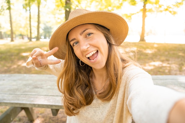 Selfie を取って自然の中で幸せな陽気な若い女性。人、ライフ スタイル、旅行のコンセプト。