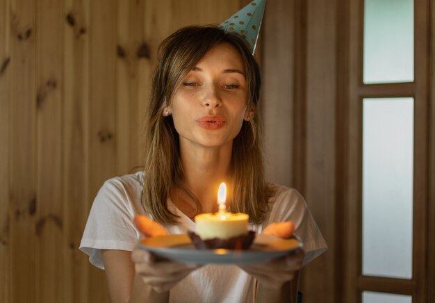 彼女の誕生日に微笑んで幸せな陽気な若い女性