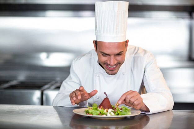 Happy chef garnishing food