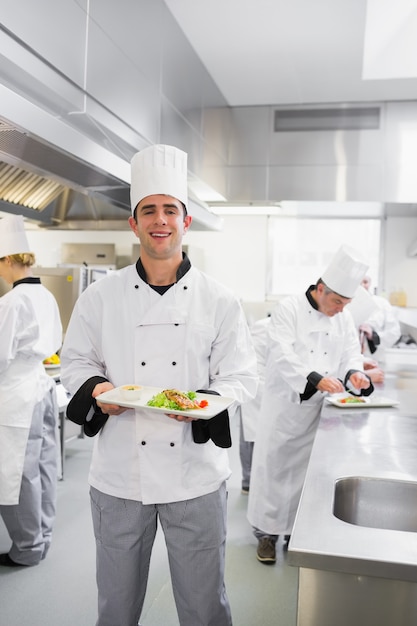 Happy chef holding a salmon dish