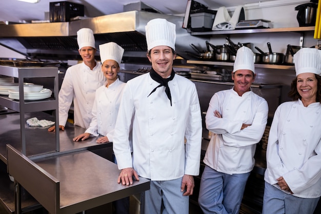 Happy chefs team standing together in commercial kitchen