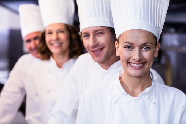 Photo happy chefs team standing together in commercial kitchen