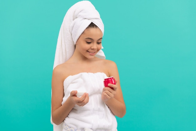 Happy child in bath tower hold face cream, beauty.