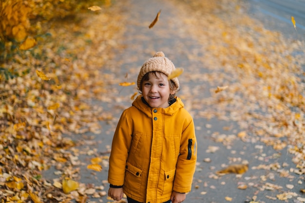 Happy child boy laughing and playing in the autumn day.