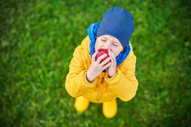 Bambino felice che gioca fuori in autunno