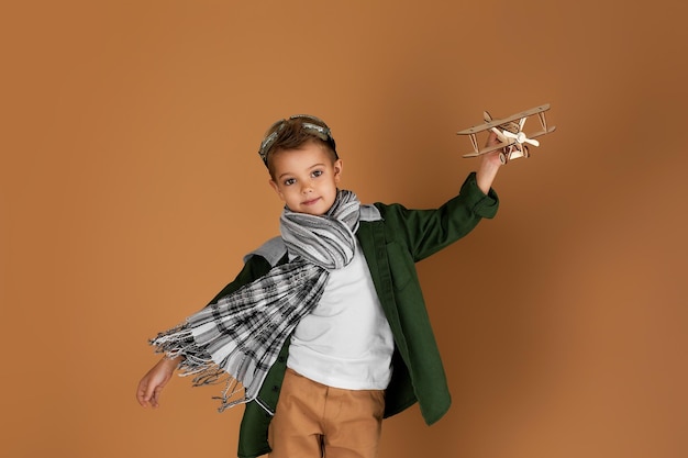 Happy child boy playing with wooden toy airplane dream