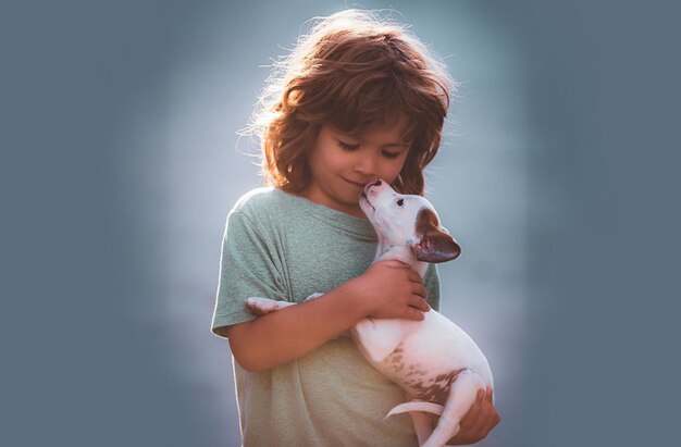 Happy child boy with a dog licking face Close up copy space