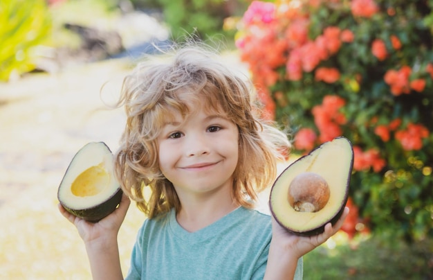 Happy child boy on the yard having fun with avocado kids summer vitamin