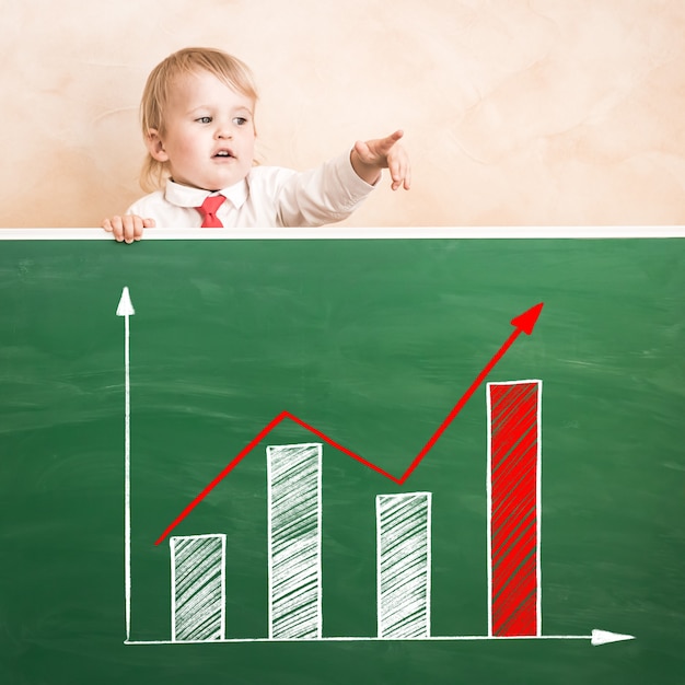 Photo happy child in class. funny kid against chalkboard. back to school. education concept