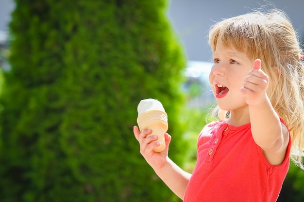 Foto bambino felice che mangia il gelato sulla natura del parco