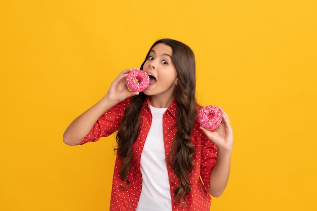 Happy child eating sweet glazed donut, yummy.