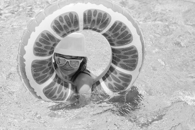 スイミングプールの水で屋外で夏休みを楽しんで幸せな子