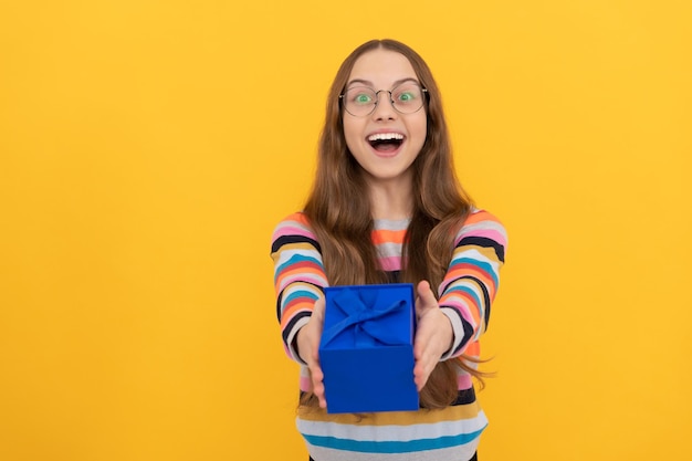 Happy child in eyeglasses giving present box for holiday purchase