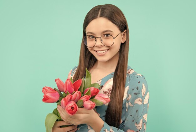 Happy child face in glasses with tulips mothers or womens day kid hold flowers