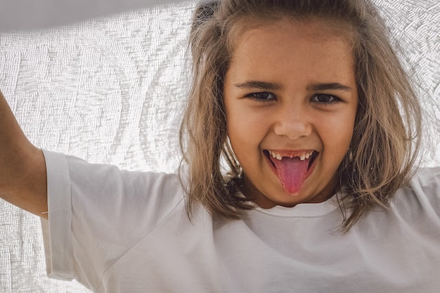 Happy child. Funny girl playing with a blanket. Smiling child girl. Cheerful child outdoors in nature