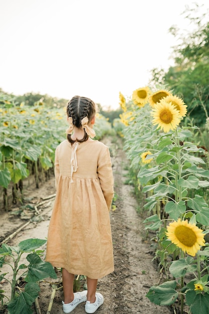 Happy child girl in the field of sunflowers