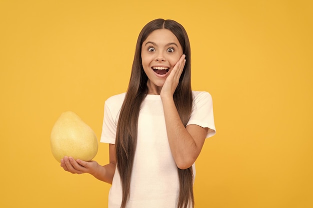 Happy child girl hold big citrus fruit of yellow pummelo or pomelo full of vitamin happiness