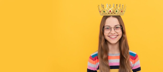 Happy child in glasses wear queen crown on yellow background victory Child queen princess in crown horizontal poster design Banner header copy space