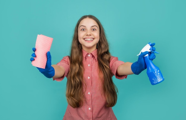 Happy child in gloves with spray bottle and microfiber rag on blue background