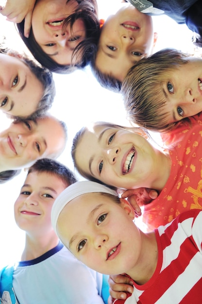 Foto gruppo di bambini felici che sorride insieme e tiene le teste molto vicine