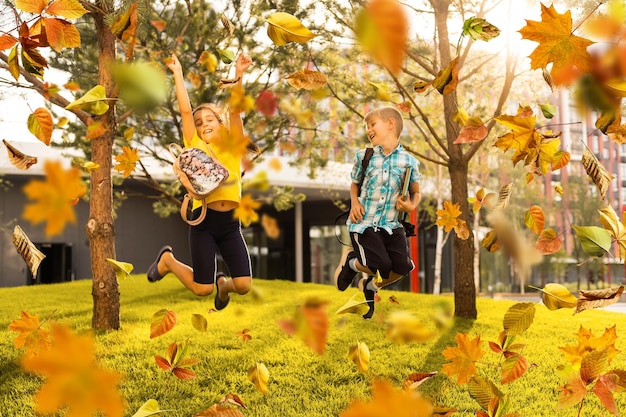 Счастливый ребенок веселится в парке осенью