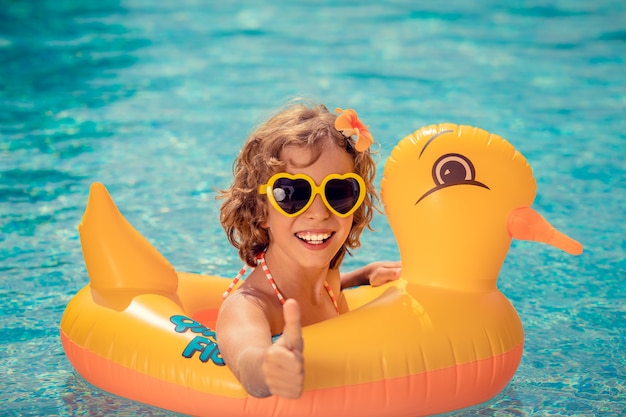 Счастливый ребенок весело на летних каникулах Забавный ребенок в бассейне Концепция активного здорового образа жизни