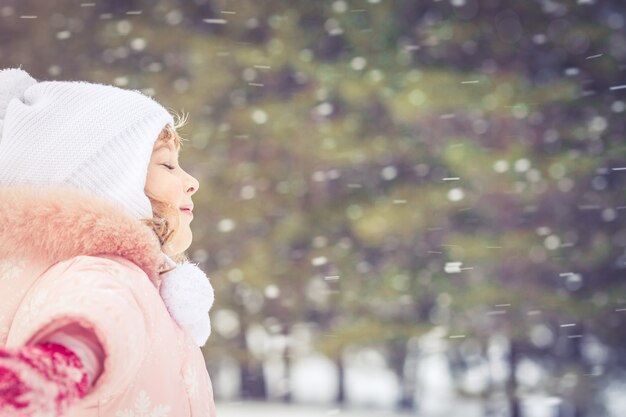 Happy child having fun in winter outdoors