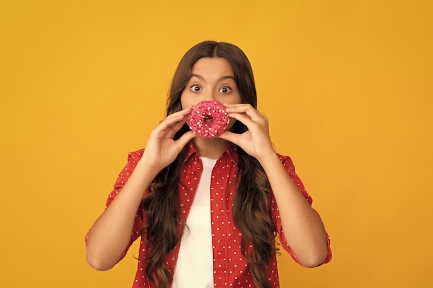 Happy child having fun with sweet glazed donut food