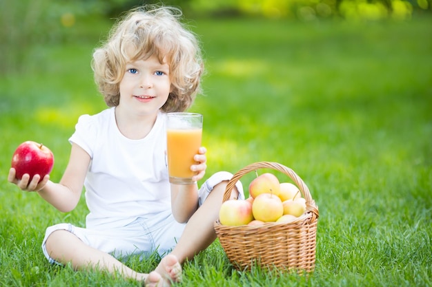 Happy child having picnic outdoors in spring park