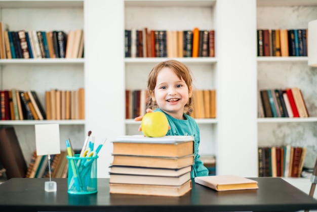 Bambino felice, cibo sano, bambina che mangia frutta a scuola