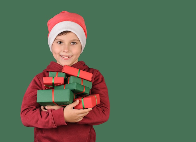 happy child holding many gifts on green background