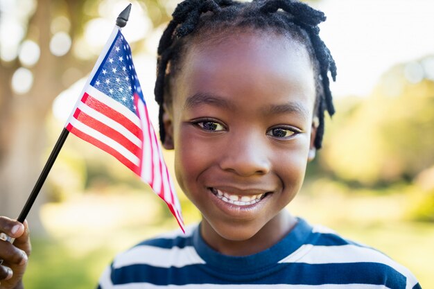 アメリカの国旗を保持している幸せな子供