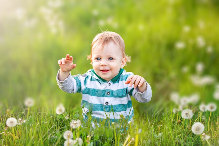 Happy child is smiling in green field of dandelions Carefree childhood