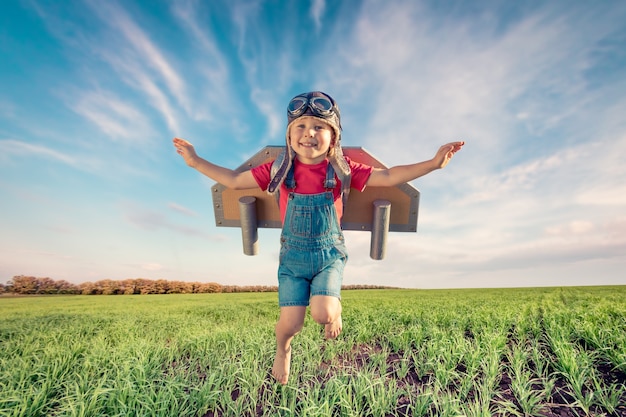 Happy child jumping against blue sky.