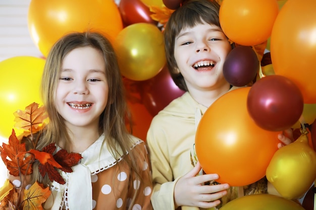 Il gruppo di bambini felici si diverte e gioca a casa con il concetto di educazione prescolare al coperto