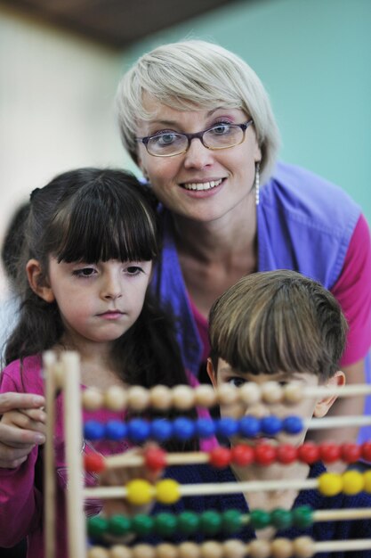 Photo happy child kids group have fun and play at kindergarden indoor preschool education concept with  teacher