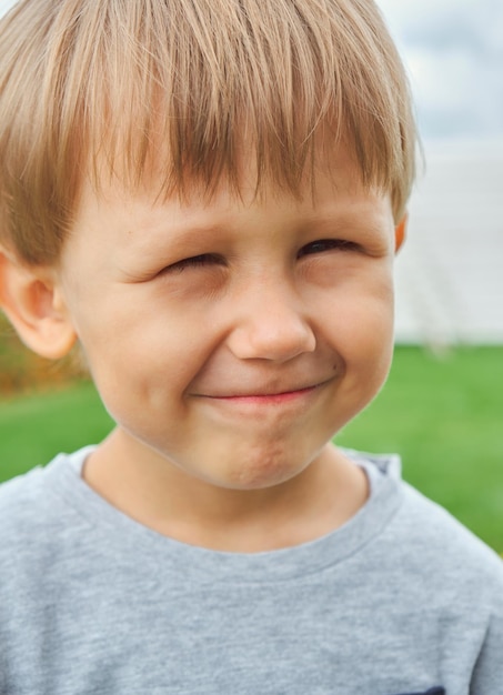 幸せな子4歳の小さな男の子が屋外で笑顔でカメラを見てください