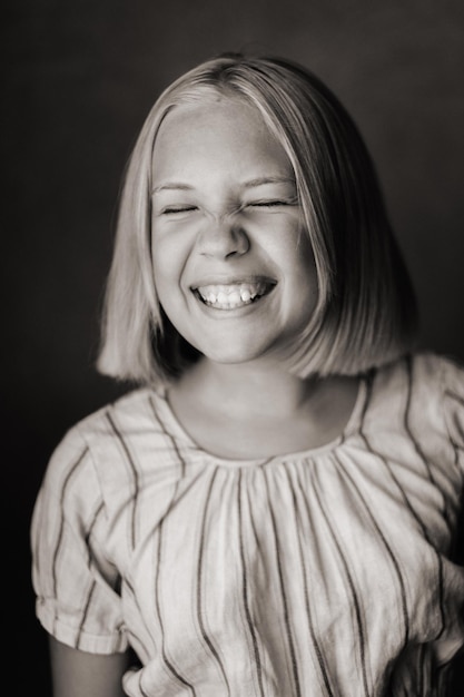 Счастливый ребенок маленькая девочка в серой футболке на бежевом фоне черно-белое фото