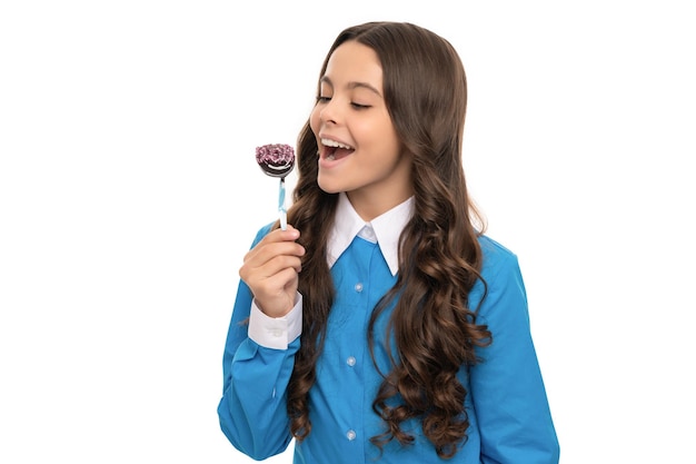 Happy child long curly hair eat chocolate candy on stick isolated on white yummy