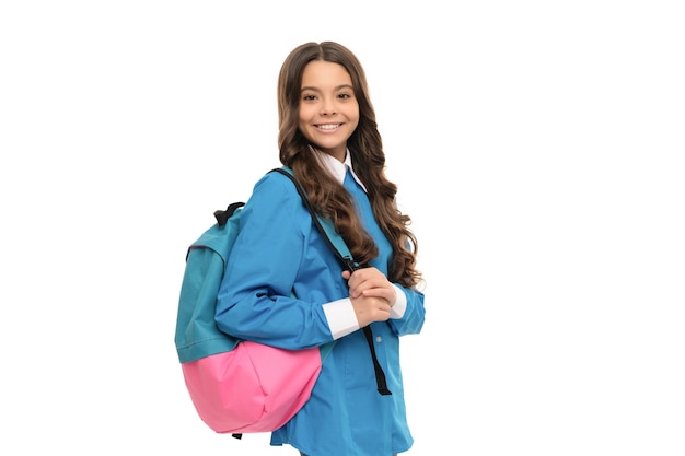 Счастливый ребенок с длинными вьющимися волосами со школьным рюкзаком, изолированным на белом, обратно в школу