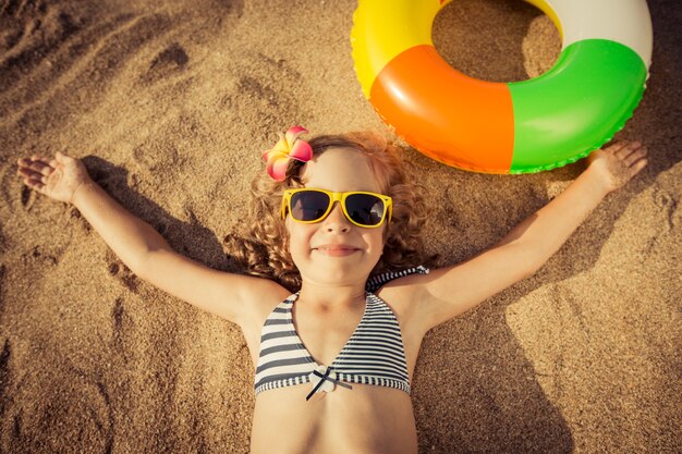 Happy child lying on the beach