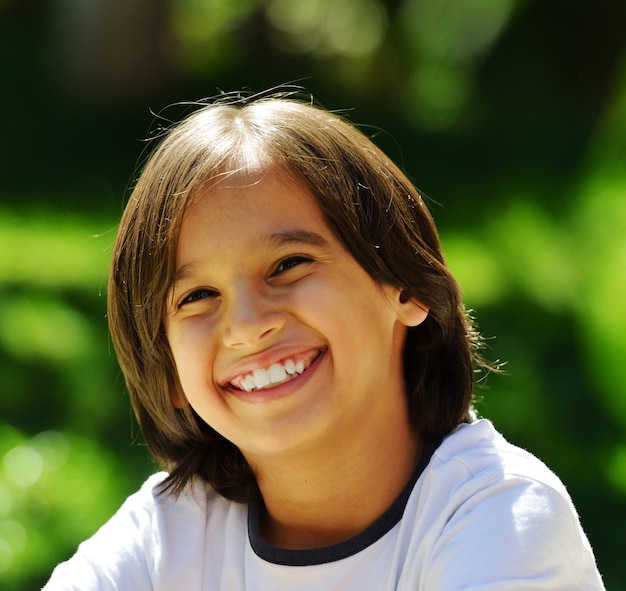 Happy child lying on a green grass