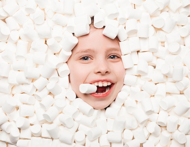 Happy child lying in marshmallows