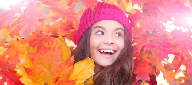 Happy child at maple tree red branch autumn nature beautiful face portrait Autumn fall child for poster design Banner header copy space