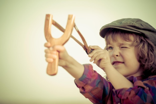 Happy child painting the cardboard with green color. Kid having fun at home. Spring Earth day holiday concept