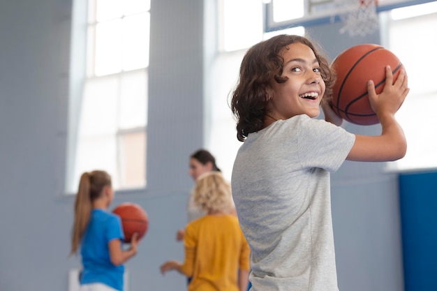 Foto bambino felice che gioca a basket