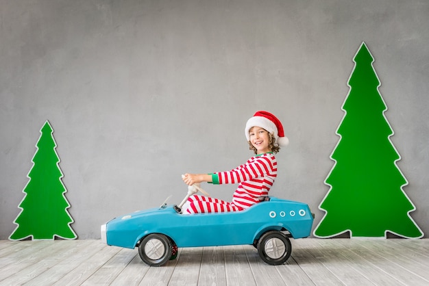 家で遊んで幸せな子。クリスマスイブの面白い子供